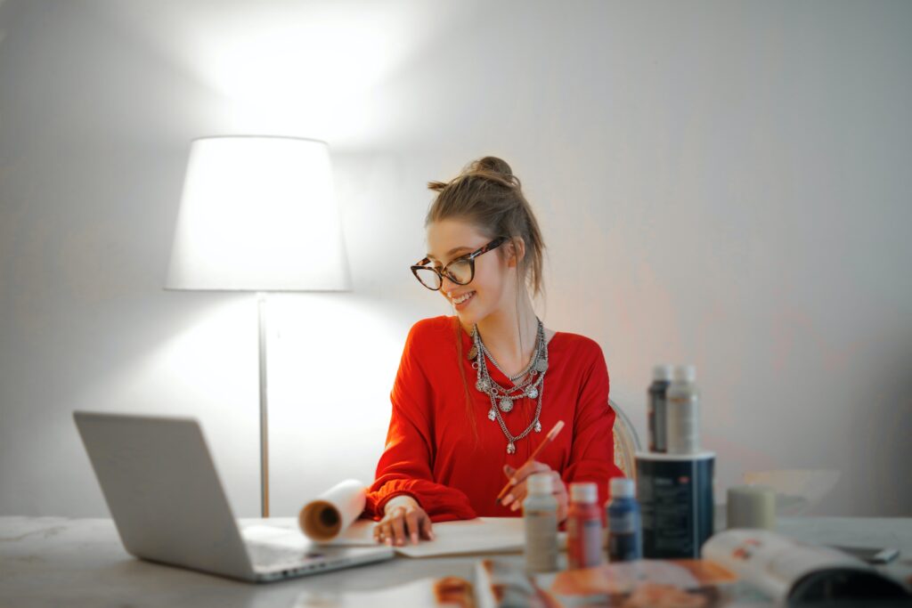 e-commerce subscription selling - lady dressed in red working at a home office desk in a minimal room