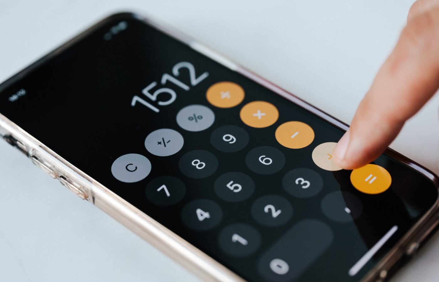Calculate gross profit margins for e-commerce - finger on a calculator app on phone