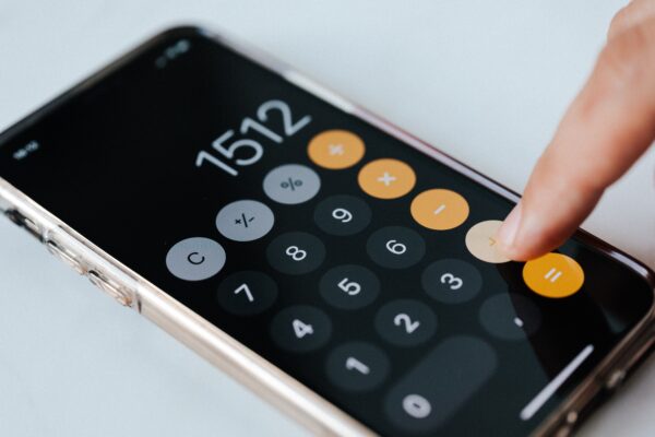 Calculate gross profit margins for e-commerce - finger on a calculator app on phone