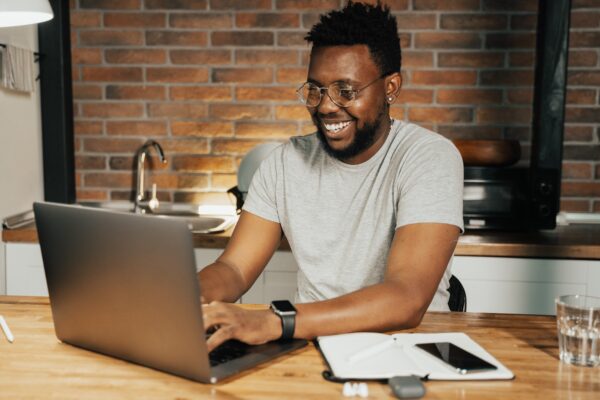R&D tax reclaim - smiling man working at a laptop at home