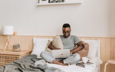 How to get a Government Gateway ID for e-commerce tax reporting - man sitting on bed working on a laptop